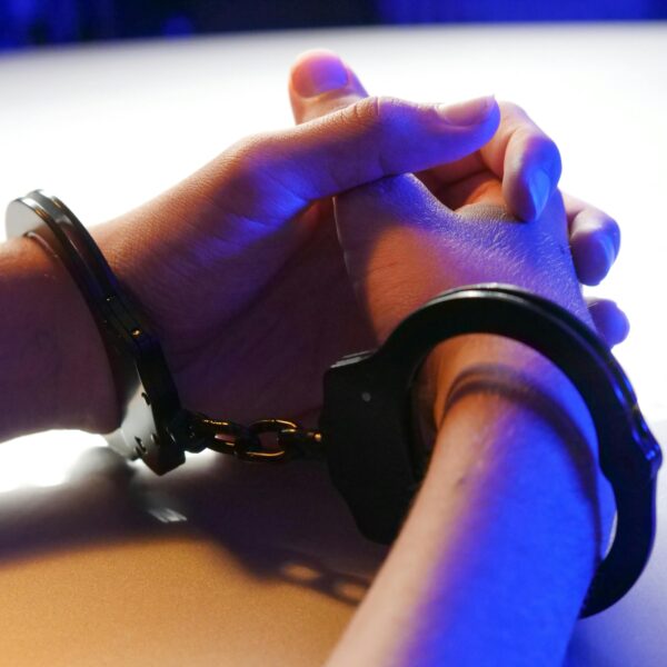 hand handcuffed and folded on table